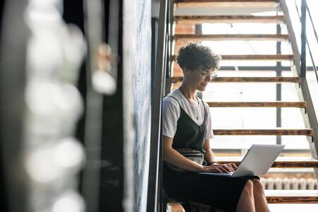 Young serious manager or designer surfing through websites
