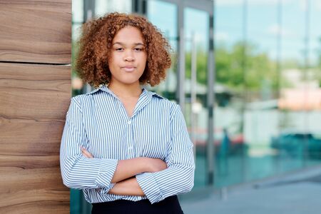 Serious young intercultural businesswoman with arms crossed on chestの写真素材