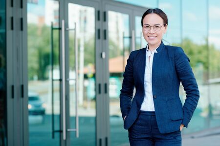 Happy young elegant businesswoman in formalwear standing in front of cameraの写真素材