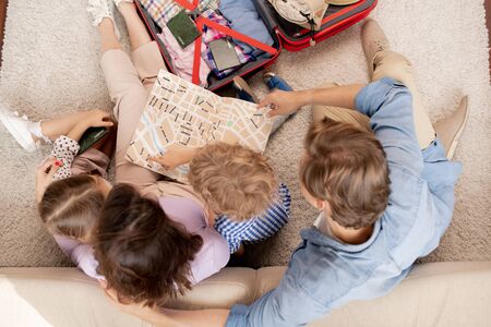 Young family of parents, their son and daughter looking at map guideの写真素材