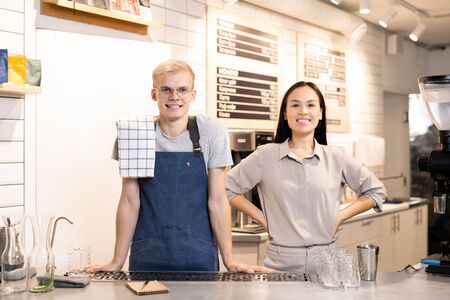 Two young successful workers of contemporary cafe or restaurant in uniformの写真素材