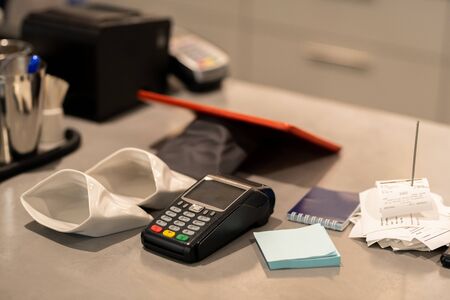 Payment machine, small empty sacks for change, notepapers and stack of receipts