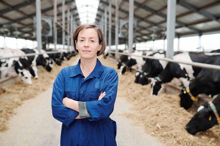 Young confident female farmer or worker of farmhouse crossing arms on chestの写真素材