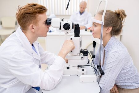Ophthalmologist and patient sitting in front of one another during check-up