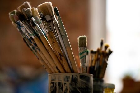 Set of paintbrushes for professional painting in tin can inside modern studio