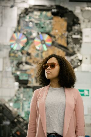 Young casual brunette female in sunglasses, grey t-shirt and pink jacketの写真素材