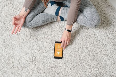 Crossed legs and hands of contemporary active girl doing yoga exercise