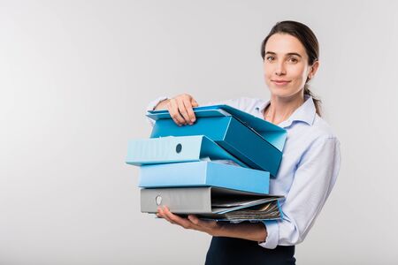 Young elegant businesswoman with stack of folders with financial documents