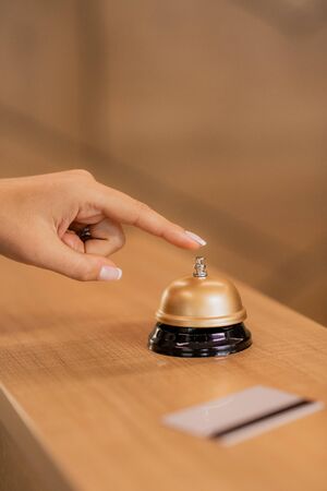 Hand of young contemporary businesswoman going to press call button on ringの写真素材