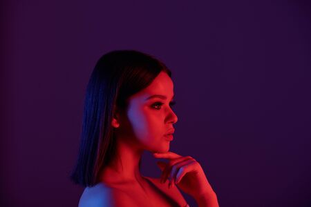 Pensive woman in neon lights