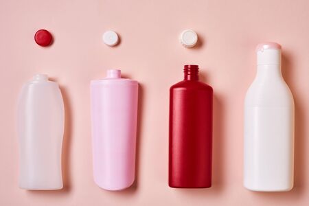 Horizontal from above flat lay conceptual image of plastic bottles with tops on pale pink backgroundの写真素材