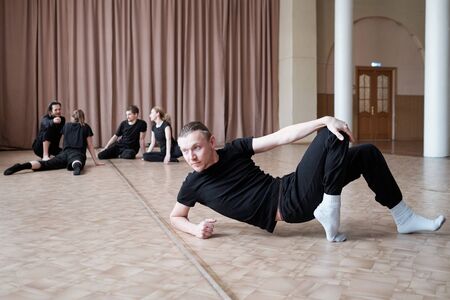 Horizontal shot of professional dance team members finishing their warming up exercises in morningの写真素材