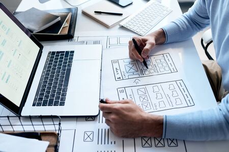 Horizontal high angle shot of unrecognizable application developer working on new software drawig...