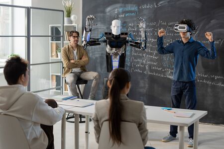 Contemporary student with vr headset demonstrating abilities of automation robotの写真素材