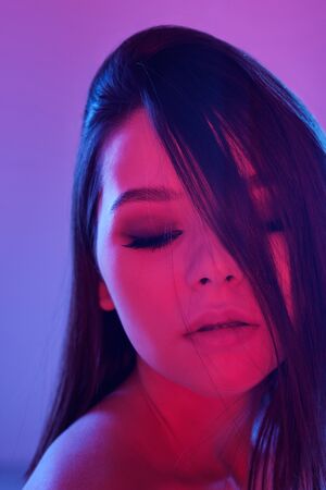 Young elegant female with dark long hair and perfect makeup in isolation
