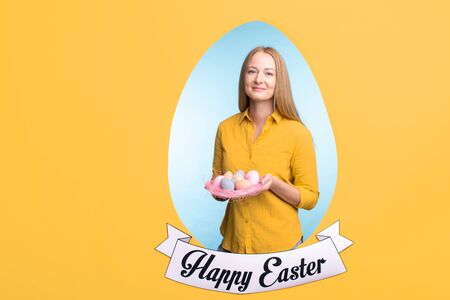 Portrait of smiling young blond-haired woman posing with Easter eggs in egg-shaped frame