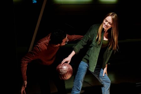 Guy looking at girlfriend and hand holding  bowling ball.の写真素材