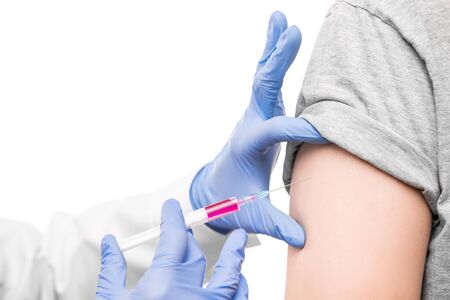 Gloved hands of nurse in whitecoat holding syringe with anti covid19 vaccine