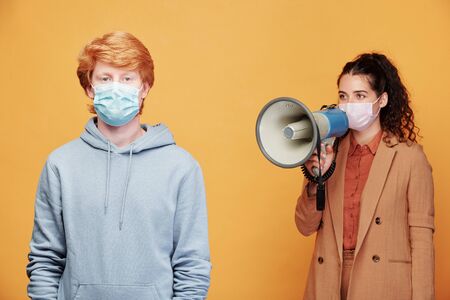 Guy in blue hoodie and mask standing on background of young female manager