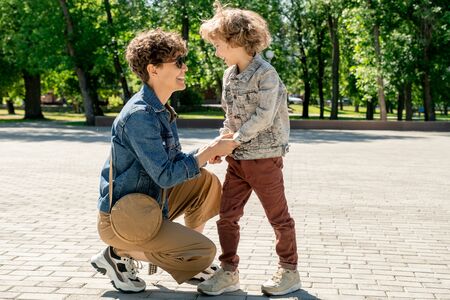 Cute laughing little boy and his happy young mother looking at one anotherの写真素材