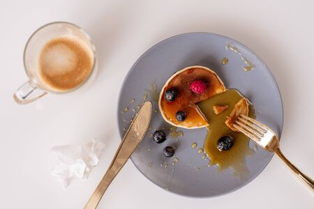 Top view of fork and knife on plate with appetizing homemade pancakeの写真素材