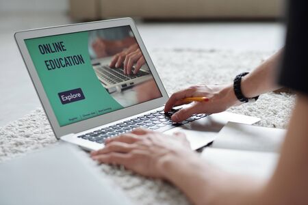 Close-up of unrecognizable student using laptop while taking online course during quarantine