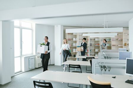 Happy young elegant white collar workers coming back to office after self-isolation and quarantine period caused by covid19 outbreakの写真素材