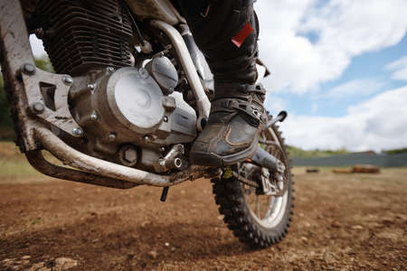 Close-up of unrecognizable motorcyclist keeping foot on pedal while launching motorbike outdoors