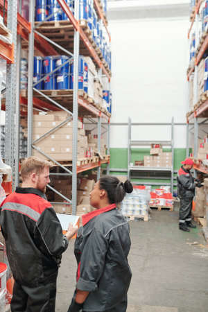 Young male head manager in uniform and his female subordinate at workの写真素材