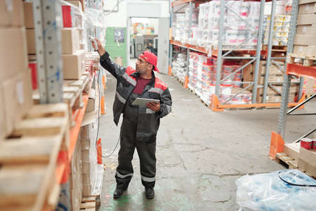 Mixed-race manager or worker of warehouse in uniform scanning qr codes
