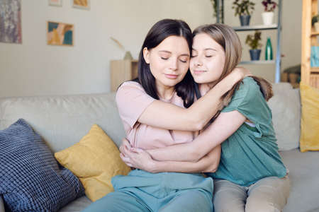 Two pretty and affectionate females in casualwear embracing each other