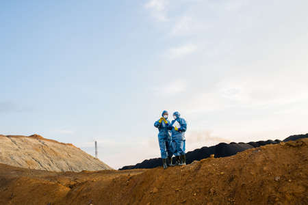 Small figures of female researchers standing on top of hill during investigation