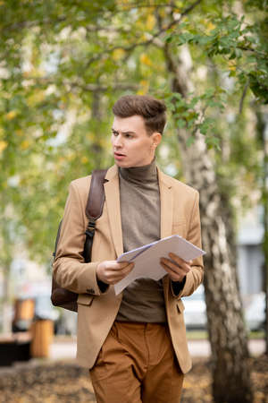 Young elegant businessman or student in smart casualwear looking aside