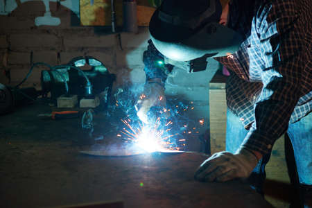 Unrecognizable man wearing protective helmet while welding something