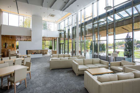 Interior of comfortable restaurant with tables and soft white leather couches