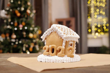 Homemade gingerbread house decorated with whipped cream and baked numbers