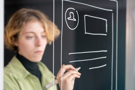 Hand of young serious mobile application developer drawing new sketchesの写真素材