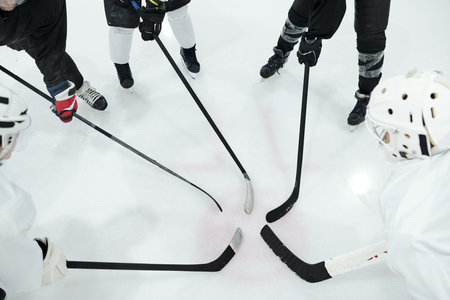 Group of hockey players in sports uniform, gloves and skates standing in circleの写真素材