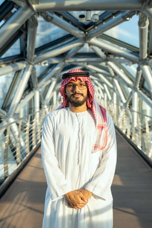 Successful young Arab delegate in national attire standing in front of cameraの写真素材