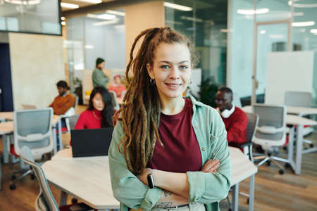 Young smiling businesswoman or designer in casualwear crossing her arms by chestの写真素材