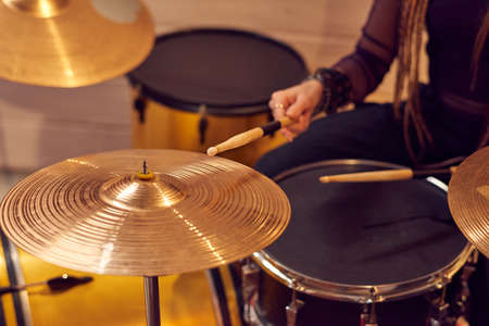 Close-up of woman playing the drums with sticks during performanceの写真素材