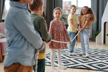 Group of children pulling the rope during game in the living room at domestic partyの写真素材