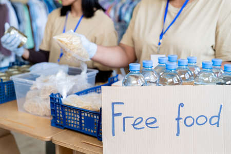 Volunteers serving free food and plastic bottles with waterの写真素材