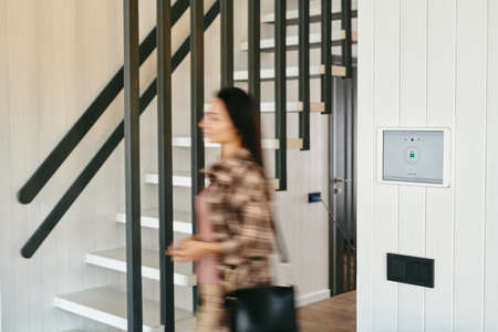 Blurred figure of young female moving in a doorway inside house