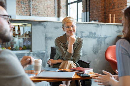 Successful businesswoman listening to one of colleagues at working meetingの写真素材