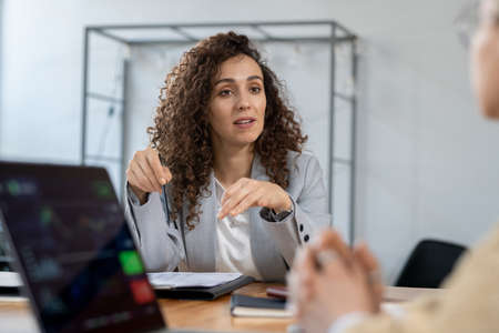 Confident businesswoman explaining one of contract points to partnerの写真素材