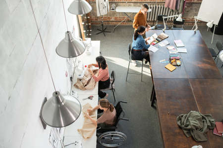 Contemporary tailors and creative fashion designers working in small groups