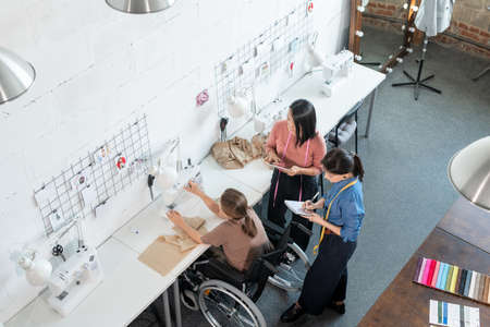 Team of professional tailors consulting during work over new fashion collectionの写真素材