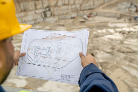 Drawing of construction in hands of builder in hardhatの写真素材