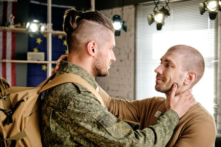 Two gay males looking at each other in front of camera in home environmentの写真素材